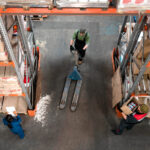 Workers working in a warehouse holding boxes.